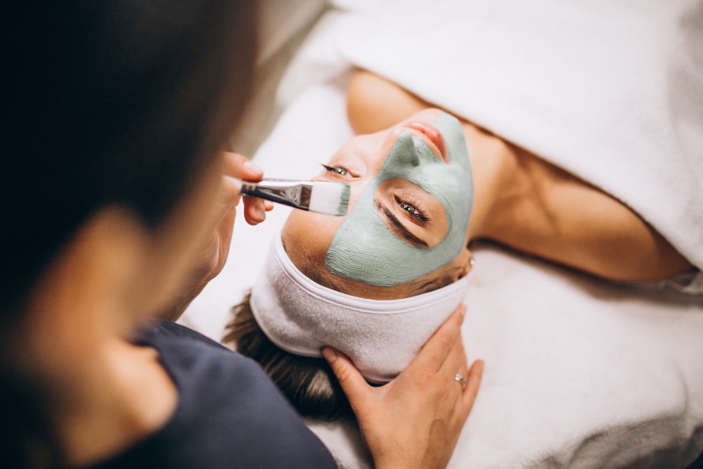 cosmetologist applying mask face client beauty salon min